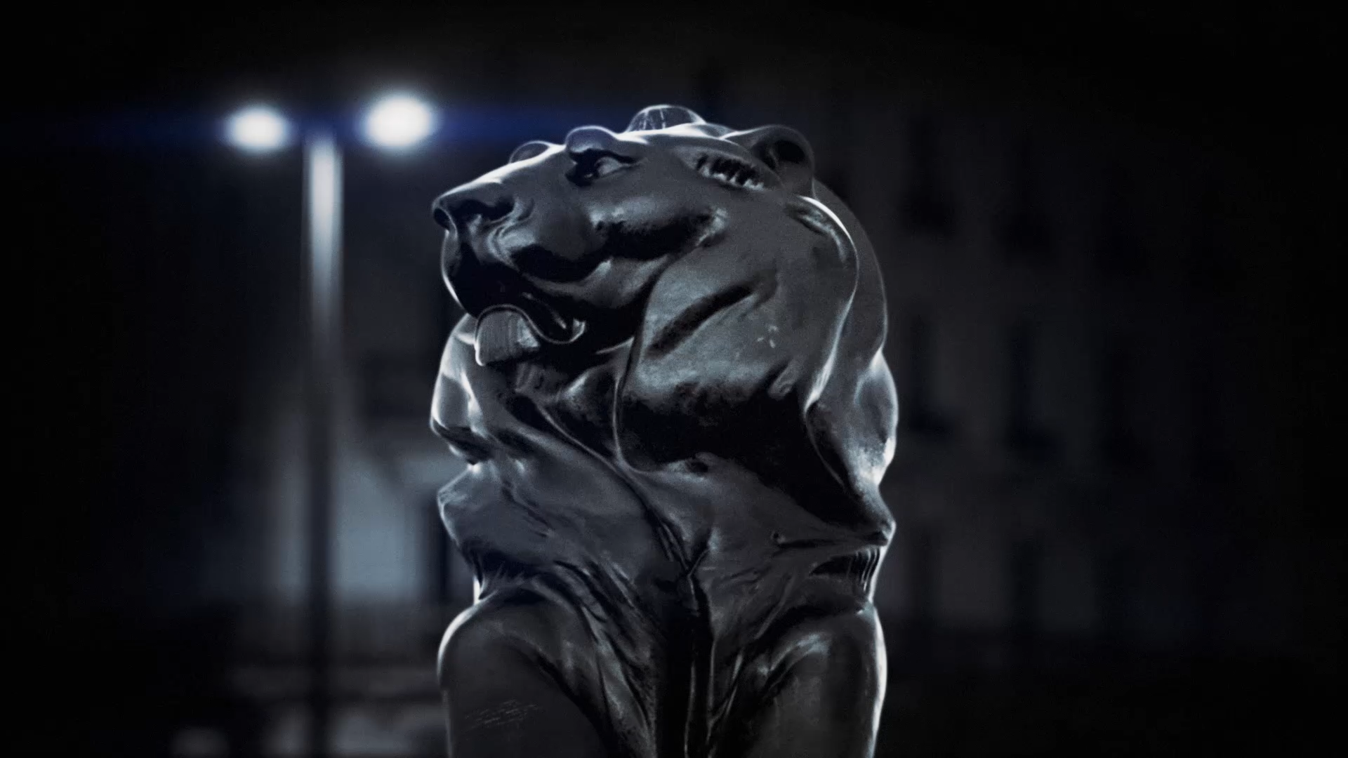 The bronze lion lit at night in a close-up from the Peugeot Avenue teaser.