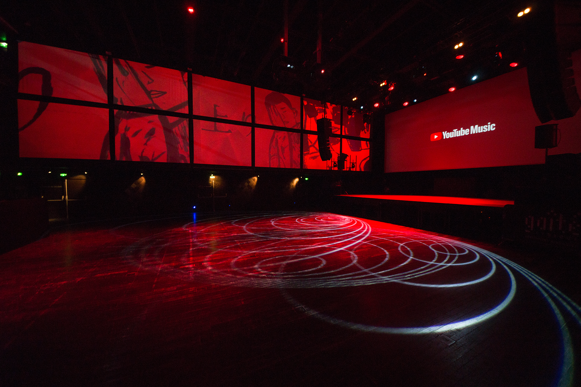 Red YouTube Music graphics across the large room, with circular lighting on the floor.