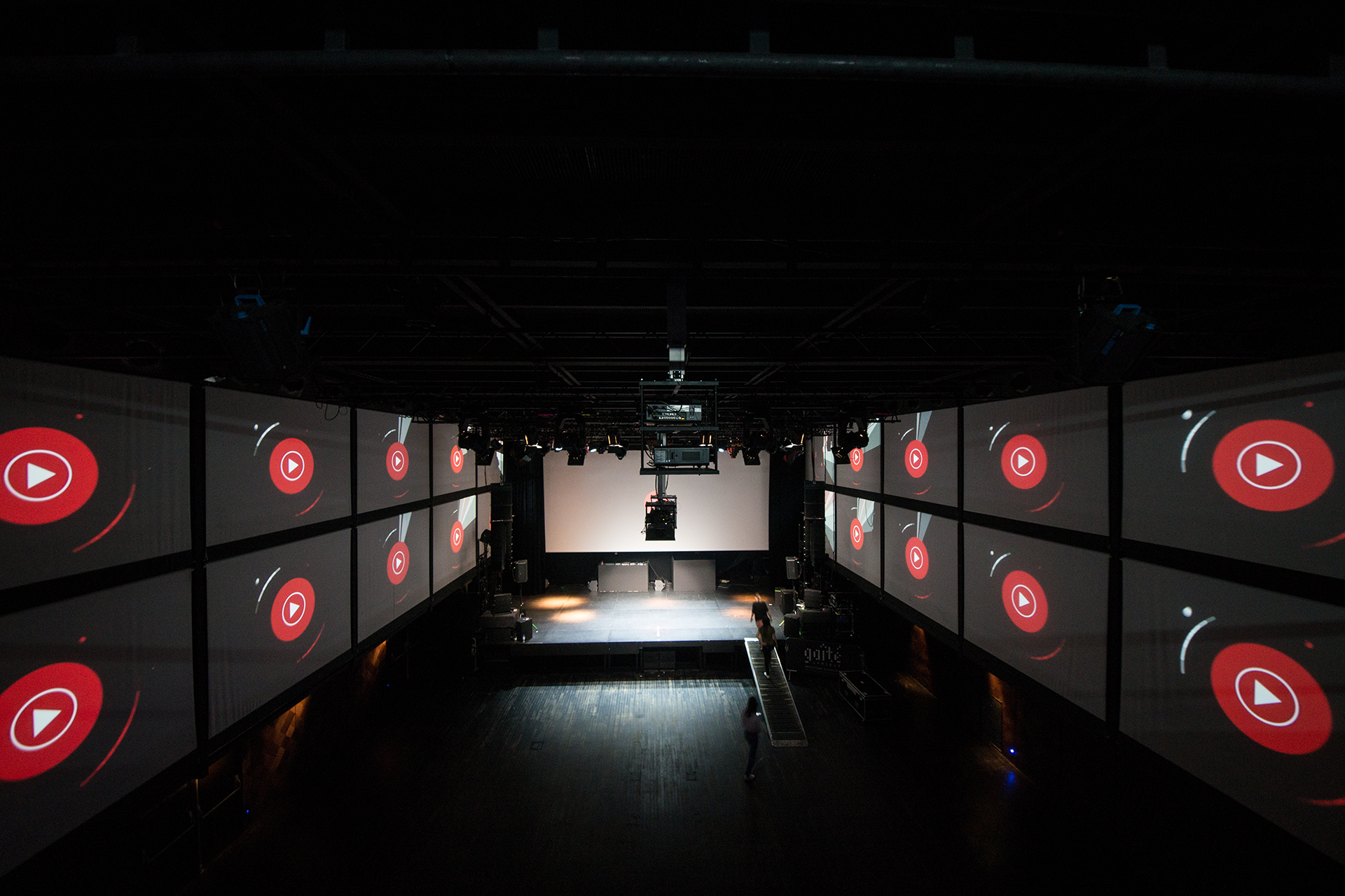 The YouTube Music play symbol animated across the stage and side walls.