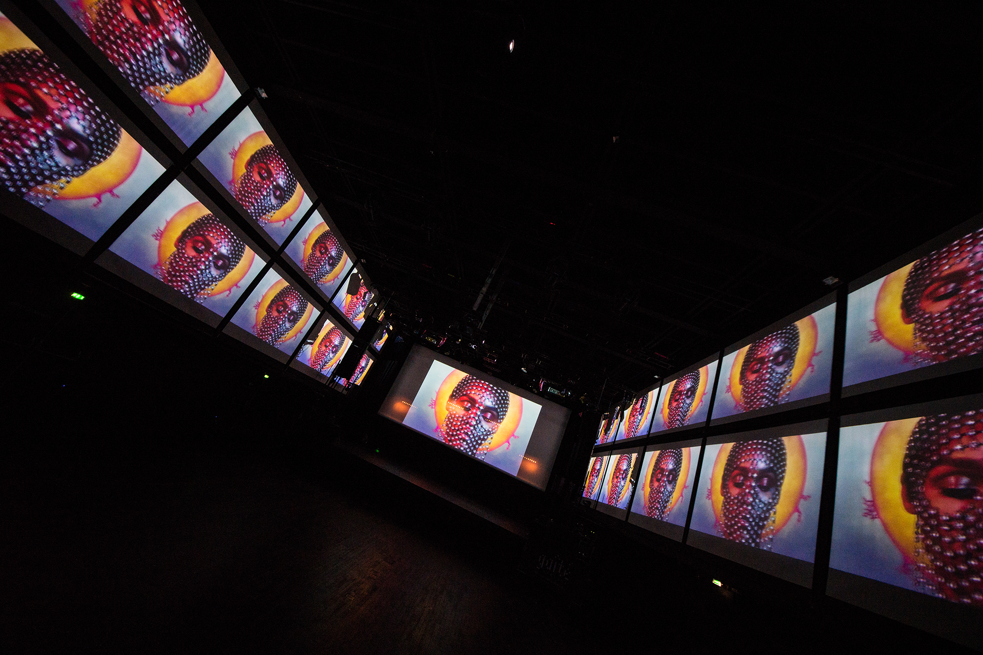 A portrait repeated across the multi-screen projection layout.