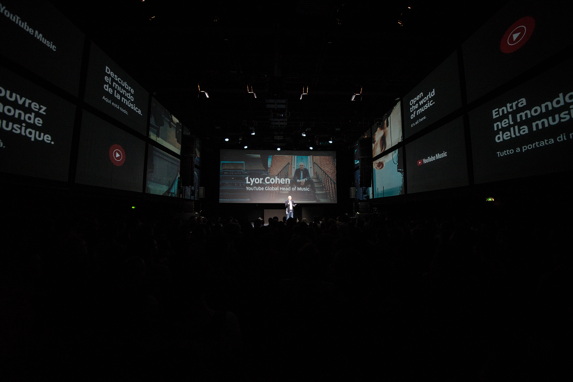 Lyor Cohen speaking in front of the multi-screen introduction graphics.